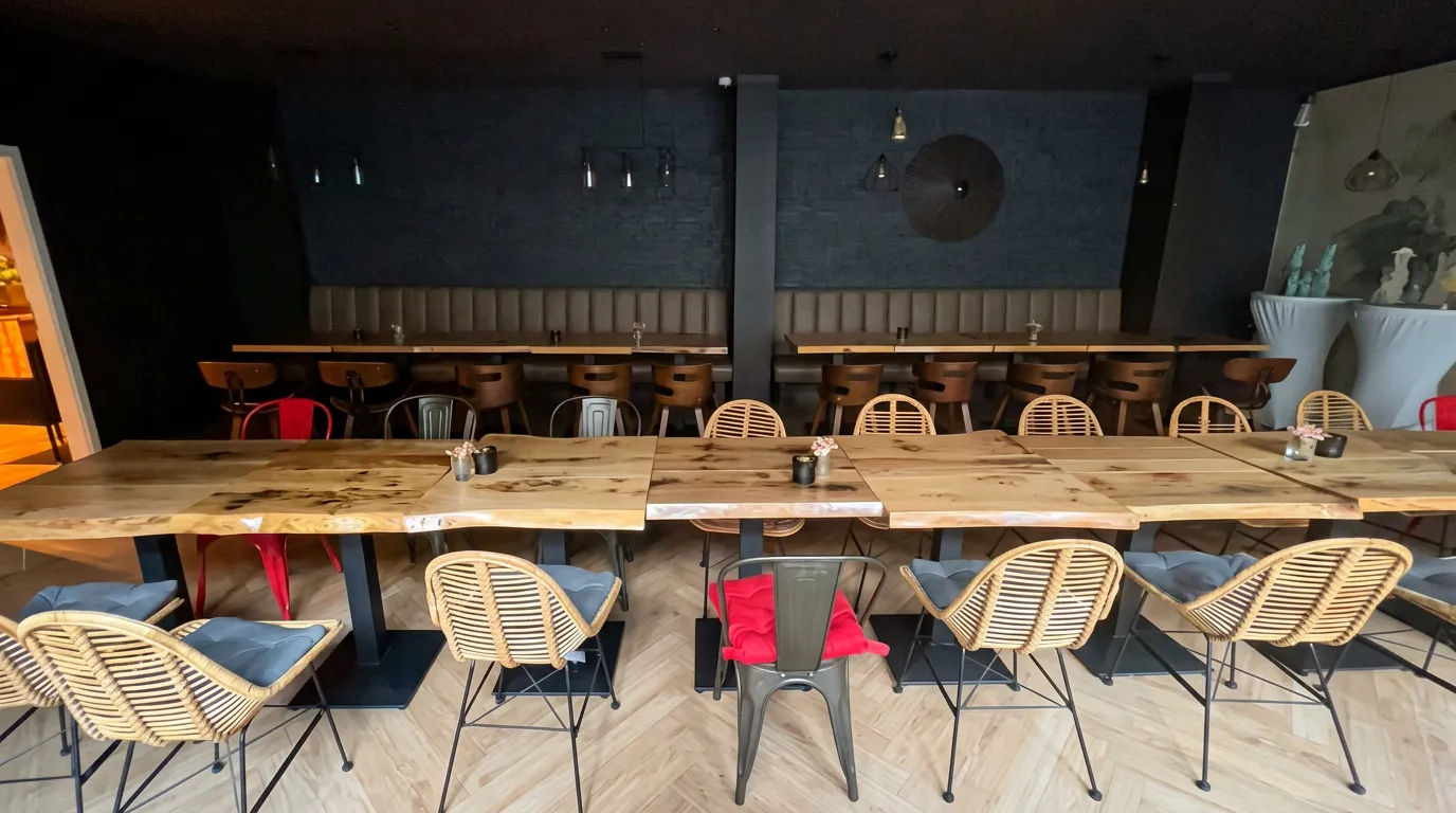 Rattanstühle an der Tafel vor der dunklen Ziegelwand